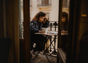 Spanish Conditional Tense – ayoung woman learning on a terrace