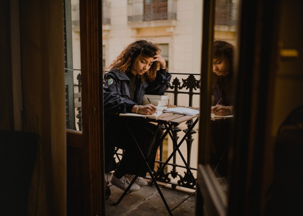 Spanish Conditional Tense – ayoung woman learning on a terrace