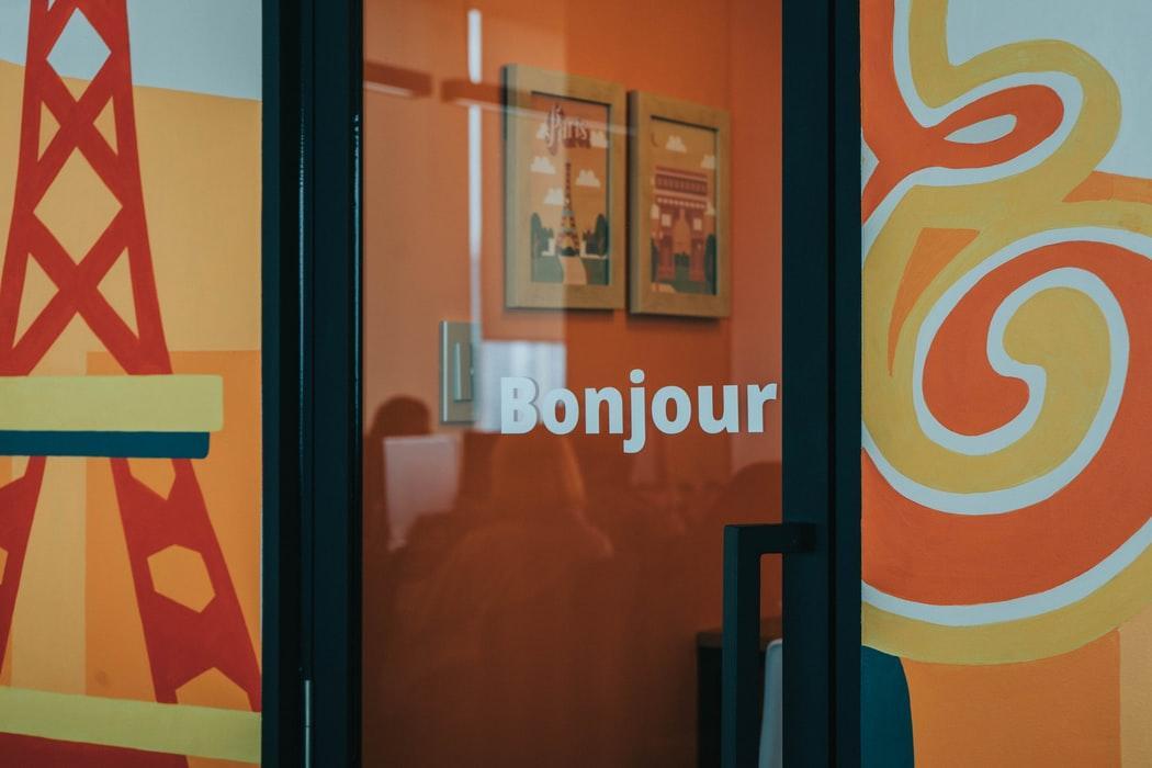 “Bonjour” (“hello” in French) written on a glass door