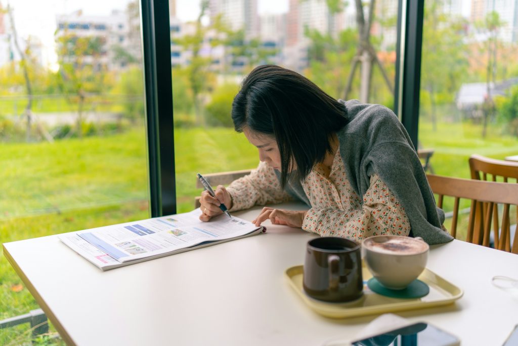 Student engaged in intermediate Spanish practice with a textbook in a coffee shop